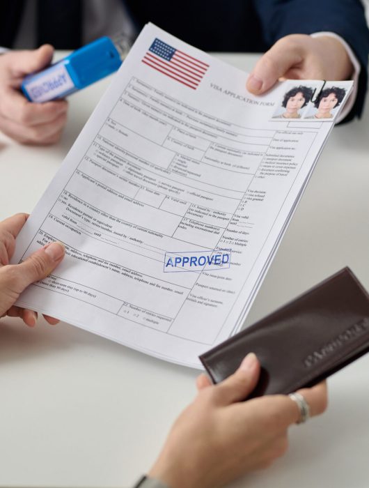 Close up of woman getting US visa in immigration office and holding approved forms